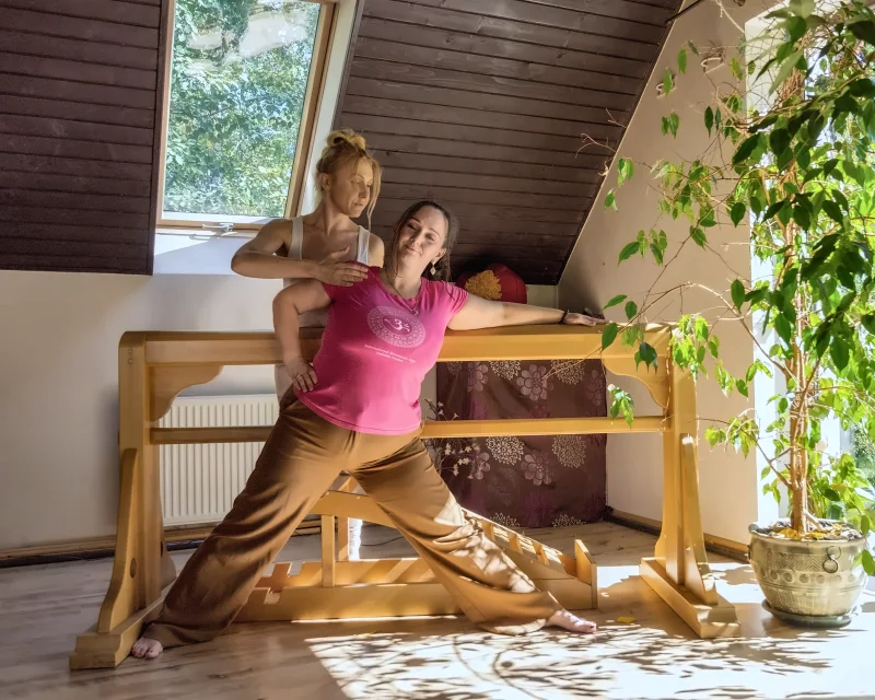 An assisted lunge stretch at the wooden barre