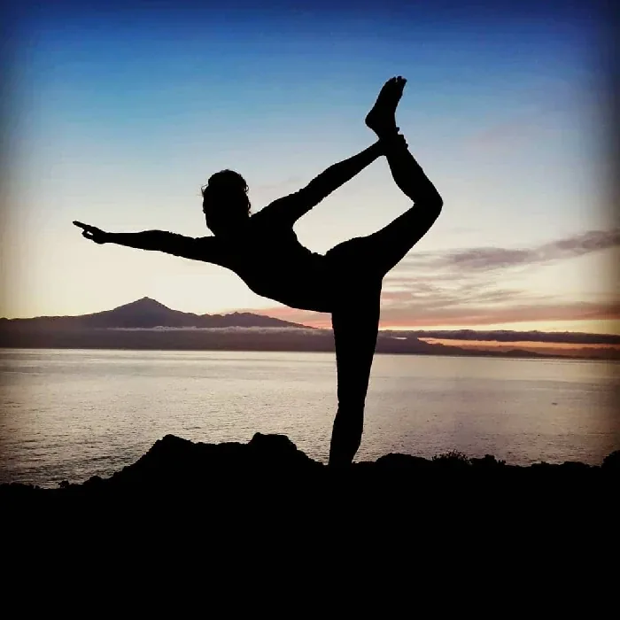 Silhouette in a yoga pose at sunrise